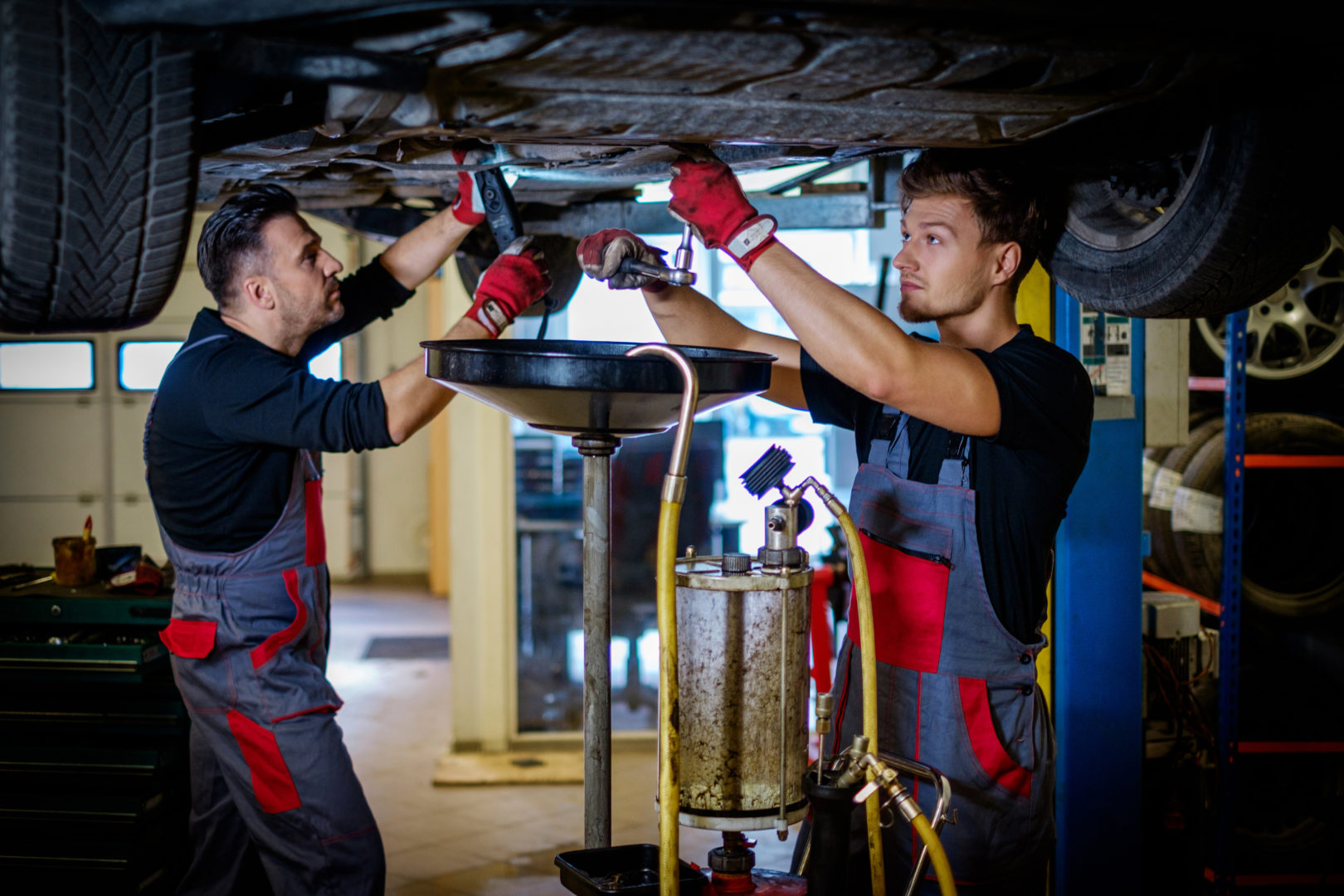 Car mechanic changes oil in a workshop