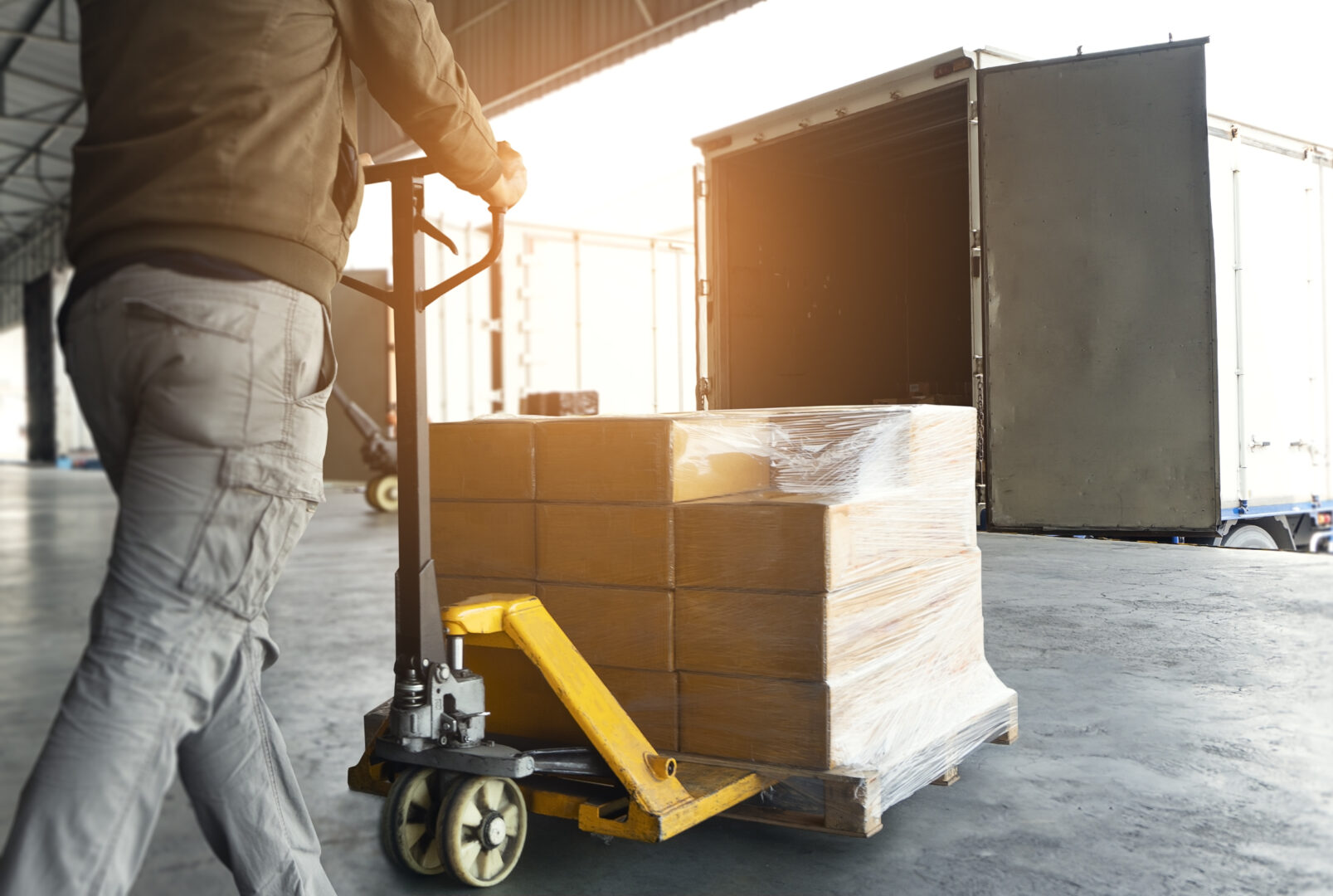 Warehouse Worker Working with Hand Pallet Truck. Worker Loading