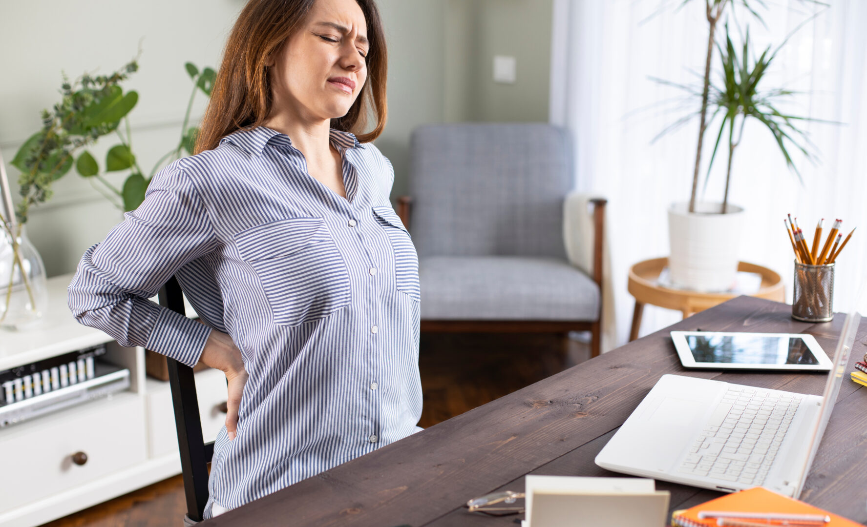 Freelancer young woman suffering with back pain