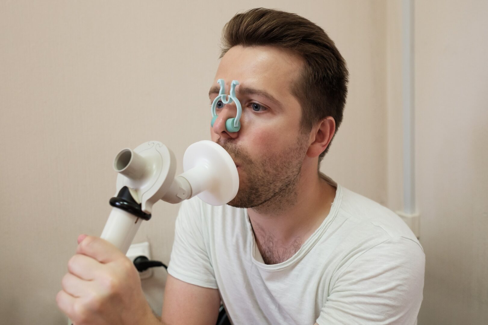 Young man testing breathing function by spirometry
