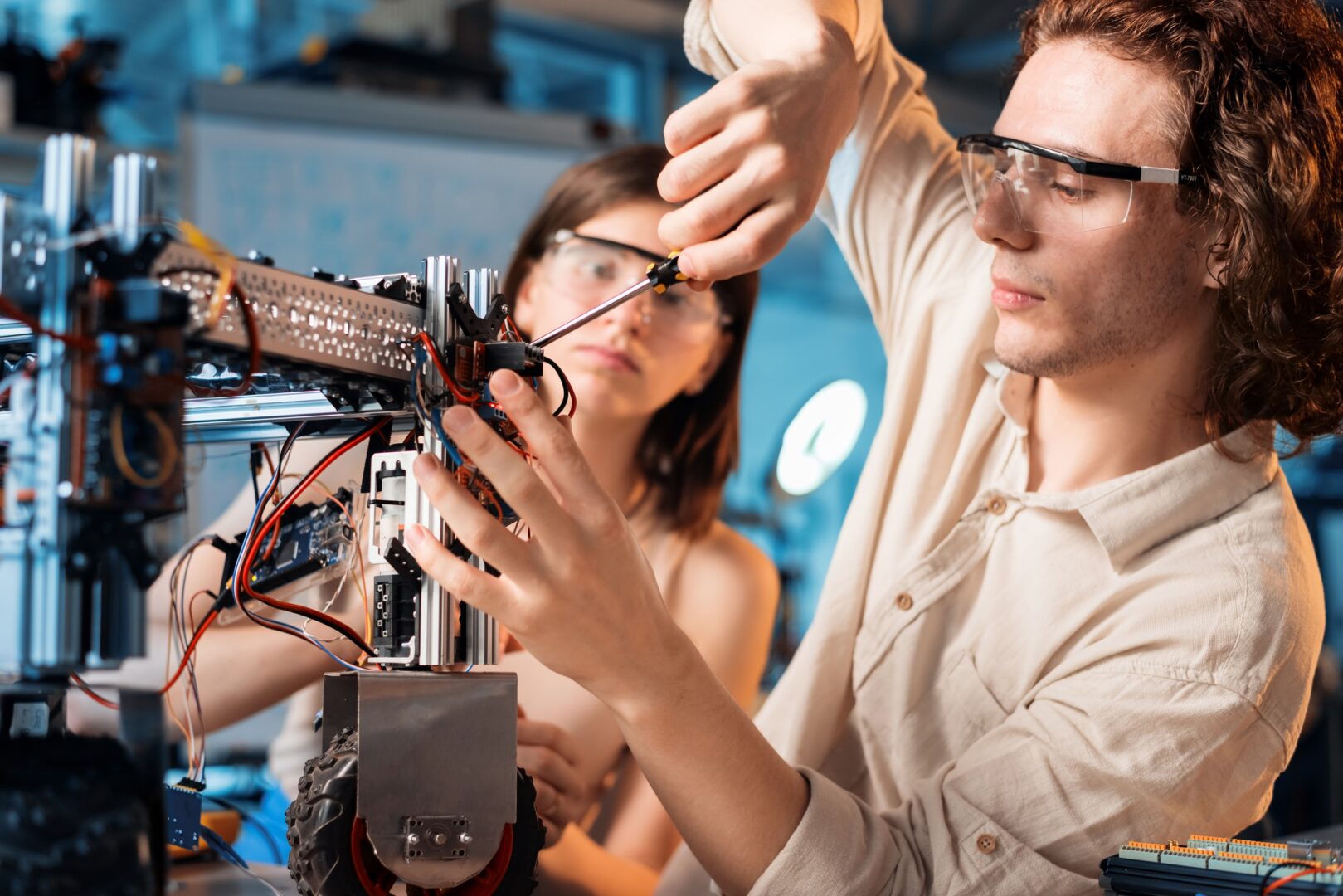 Young man and woman doing experiments in robotics in a laboratory