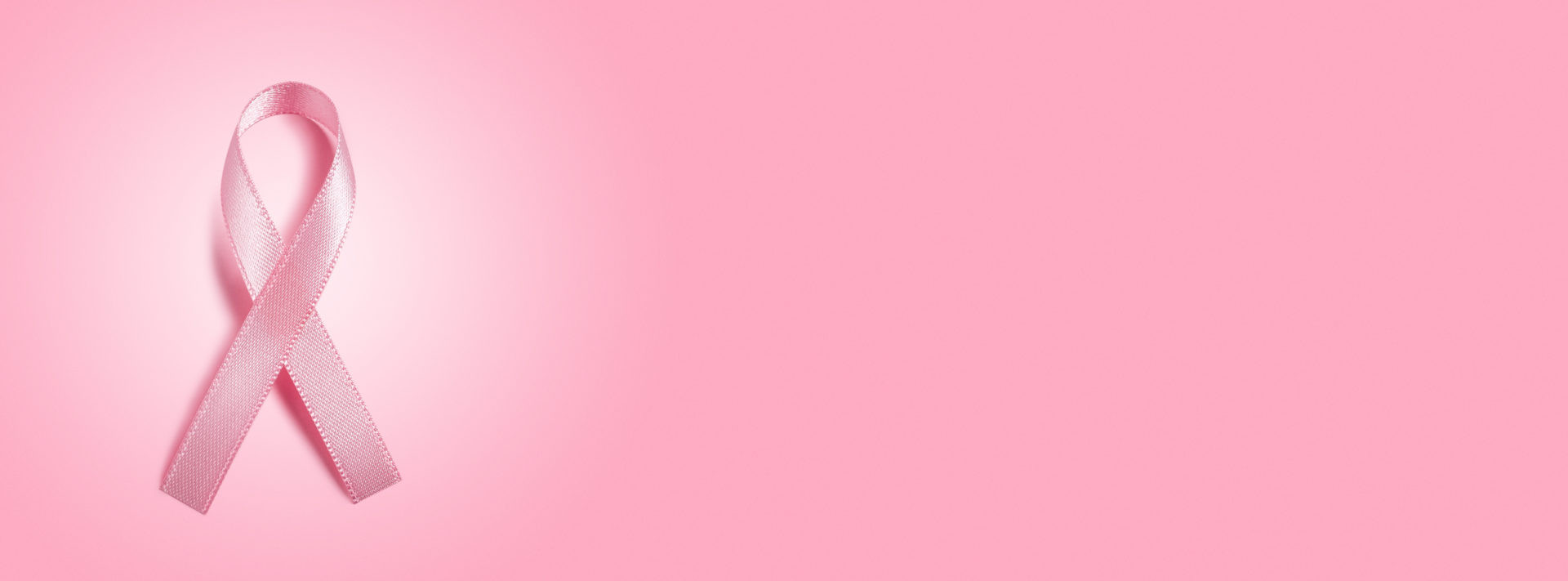 pink ribbon on pink background with copy space